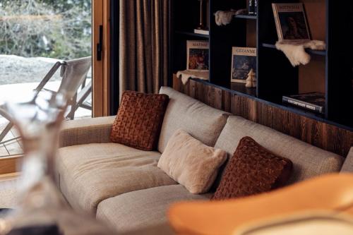un salon avec un canapé et une fenêtre dans l'établissement Antarès URSA 002 - luxury apartment ski inski out, à Méribel