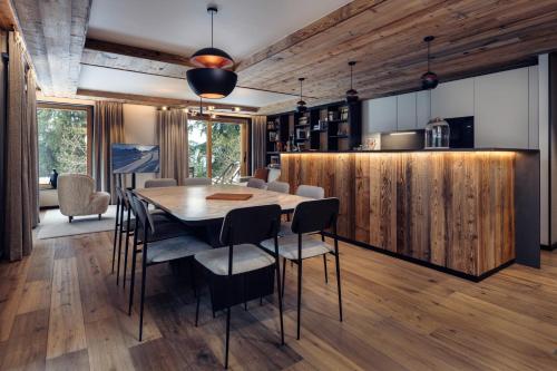 une cuisine et une salle à manger avec une table et des chaises dans l'établissement Antarès URSA 002 - luxury apartment ski inski out, à Méribel