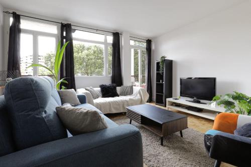 un salon avec deux canapés et une télévision dans l'établissement Bright apartment overlooking the Canal du Midi, à Toulouse