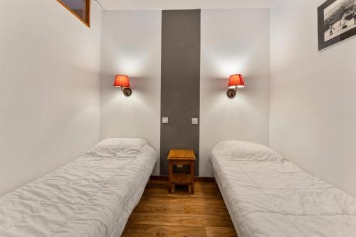 deux lits dans une chambre avec des lumières sur le mur dans l'établissement Résidence Les Hauts De Preclaux - Studio avec jolie vue sur la place des Orres 1800 MAE-8011, aux Orres