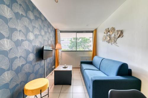 un salon avec un canapé bleu et une table dans l'établissement Apartment - 4P - Villeurbanne, à Villeurbanne