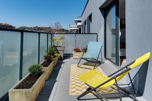 2 chaises assises sur le balcon d'un bâtiment dans l'établissement Origami - T3 new & cozy 2 steps from the center of Annecy with WiFi &, à Annecy