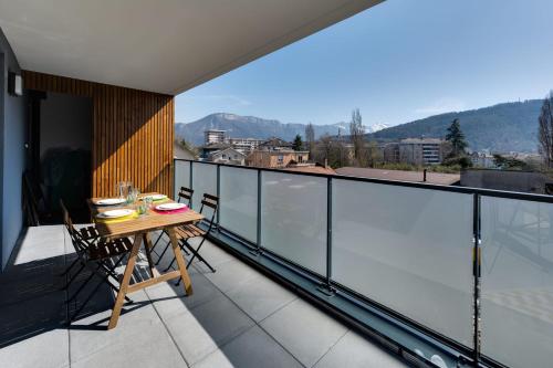 Elle comprend un balcon avec une table et des chaises en bois. dans l'établissement Origami - T3 new & cozy 2 steps from the center of Annecy with WiFi &, à Annecy