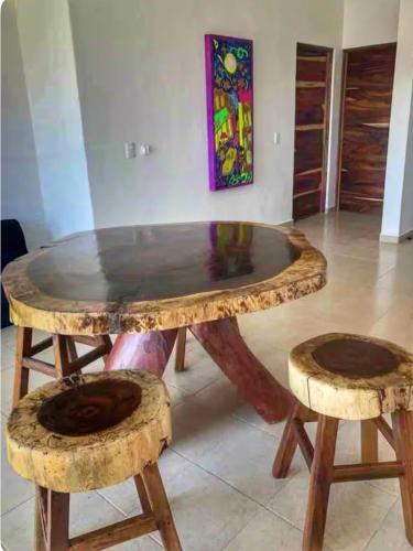 a wooden table and stool with a glass top at Apartment 3 Maleconcito del Sol Barra de Navidad in Barra de Navidad