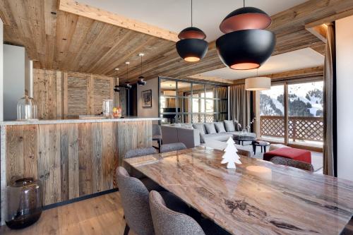 une salle à manger avec une grande table et des chaises en bois dans l'établissement Antarès MIRA 102 - luxury apartment ski inski out, à Méribel