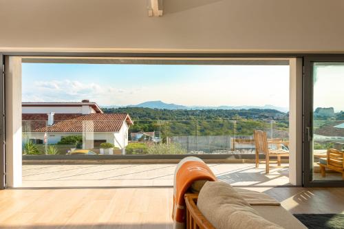 d'un salon avec une grande porte coulissante en verre. dans l'établissement BLUE MILADY - KEYWEEK holiday home swimming pool sea view, à Biarritz