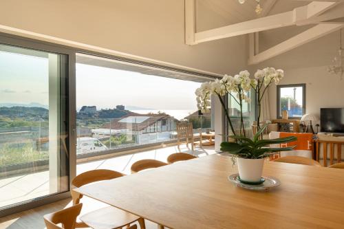 une salle à manger avec une table et une grande fenêtre dans l'établissement BLUE MILADY - KEYWEEK holiday home swimming pool sea view, à Biarritz