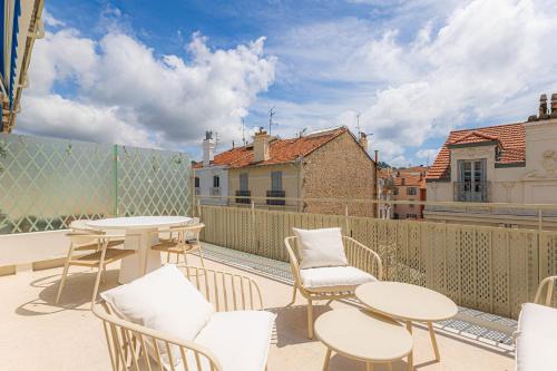 un patio avec tables et chaises sur un balcon dans l'établissement Sublime 3 pièces entièrement rénové dans le centre de Cannes, à Cannes