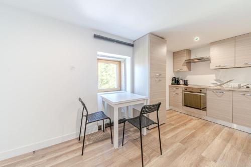 Una cocina con mesa y sillas y una ventana. en Maison Fontanières Studio Navarre 1 person, en La Mulatière