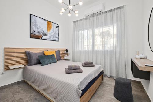 a bedroom with a large bed and a window at FatCow Beach Apartment in Larnaka