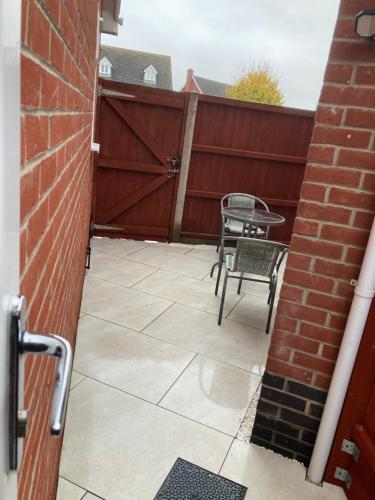 a patio with a chair and a table and a fence at Guest house paradiso in Great Cornard