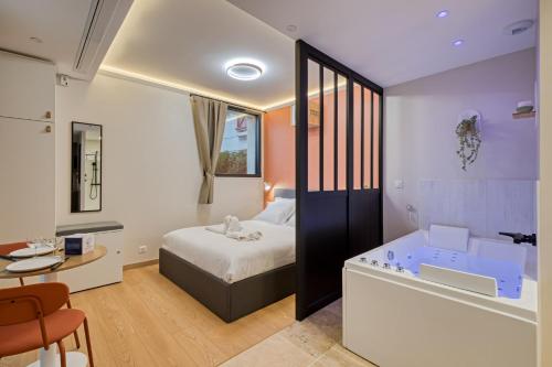 Cette chambre comprend un lit et une baignoire. dans l'établissement La Love-Room d'Alice balnéo et vidéo-projecteur !, à Rouen