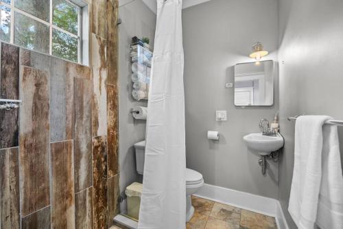 a bathroom with a toilet and a sink and a shower at Half Off SALE! Downtown Home with King Bed FirePit Free Parking and Huge Back Yard Filming Allowed in Wilmington