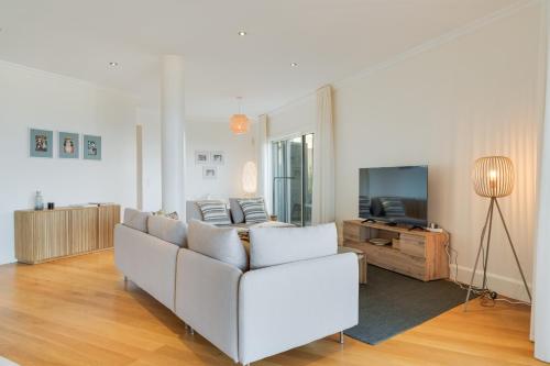a living room with a white couch and a television at Sublime View Villa by Atlantic Holiday in Funchal