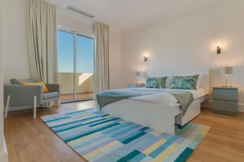 a bedroom with a bed and a chair and a window at Sublime View Villa by Atlantic Holiday in Funchal