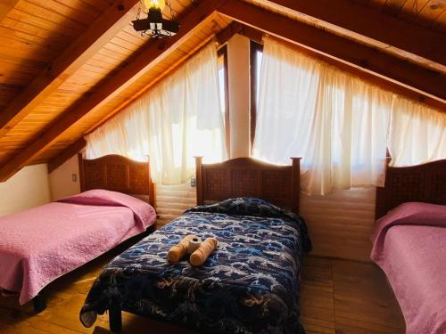 a bedroom with two beds in a attic at Cabañas Ojo de Agua in Mazamitla
