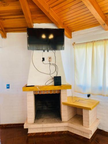 a living room with a tv above a fireplace at Cabañas Ojo de Agua in Mazamitla
