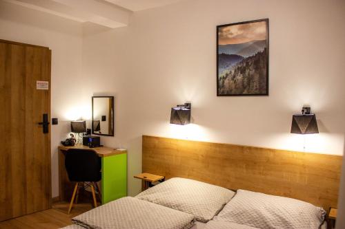 a bedroom with a bed and a desk in it at Pod Gromadzyniem Resort in Ustrzyki Dolne