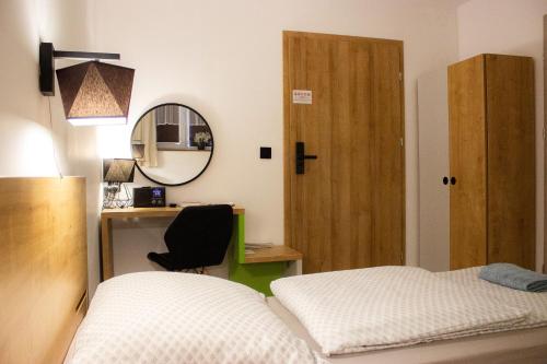 a bedroom with a bed and a desk and a mirror at Pod Gromadzyniem Resort in Ustrzyki Dolne