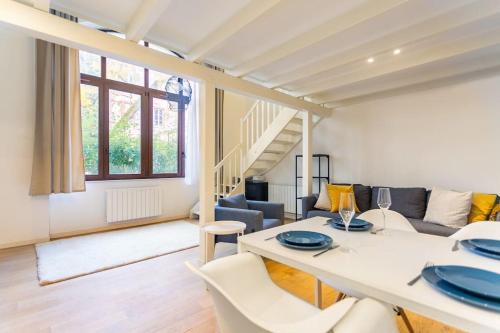 un salon avec une table et un canapé dans l'établissement Duplex Spacieux au calme, à Strasbourg