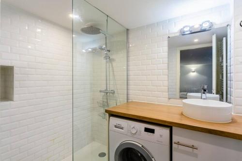 une salle de bain avec un lavabo et une machine à laver dans l'établissement Duplex Spacieux au calme, à Strasbourg