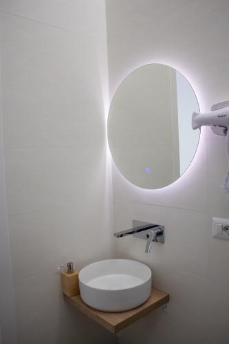 a white bathroom with a sink and a mirror at WANDERLUST SPACCANAPOLI Points Of View in Naples
