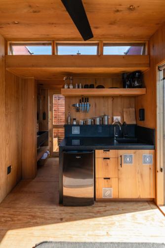 a kitchen with a black counter and a sink at Wander Cabins, Cabaña con Vista Única a la Sierra de Artega in Arteaga