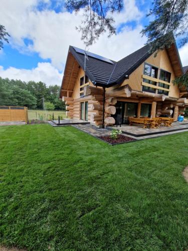 a log cabin with a lawn in front of it at Chata Braci Warchały in Warchały