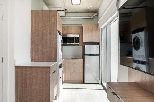 a kitchen with wooden cabinets and a refrigerator at Milan Aventura Hotel in Aventura