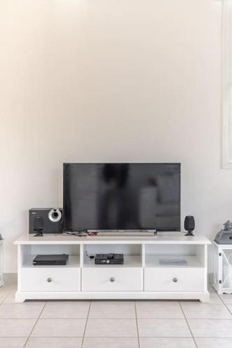 a white entertainment center with a flat screen tv on it at Villa Fedrita in Acharavi