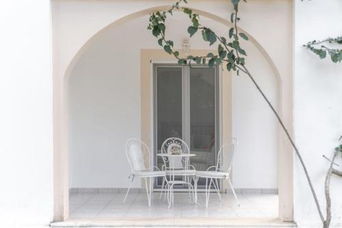 an archway with a table and chairs on a porch at Villa Fedrita in Acharavi