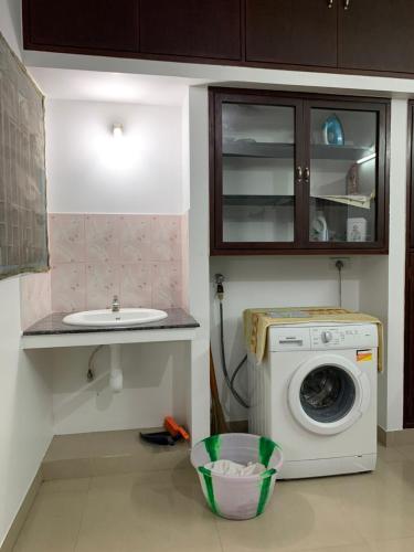 een keuken met een wasmachine en een wastafel bij HERITAGE TOWN Ac room for 2 in Pondicherry