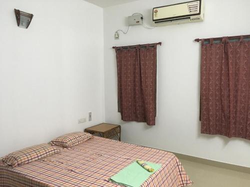 een kleine slaapkamer met een bed en een televisie bij HERITAGE TOWN Ac room for 2 in Pondicherry