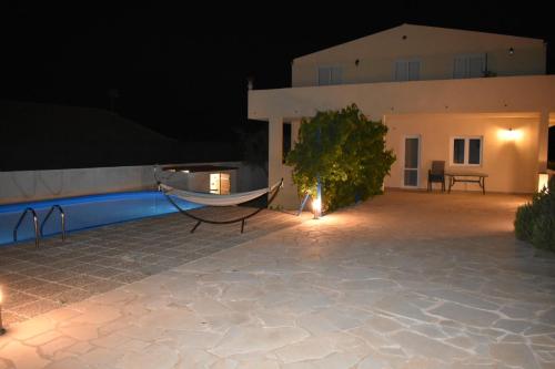 a hammock on the patio of a house at night at Rosmarino 1 Marina di Ragusa in Camemi