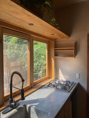 a kitchen counter with a sink and a window at Habitación Privada Sol - Aldea Corazón - StarLink in Santa María Tonameca