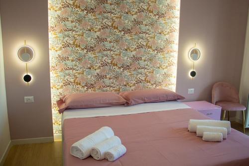 a bedroom with a bed with rolled towels on it at WANDERLUST SPACCANAPOLI Points Of View in Naples