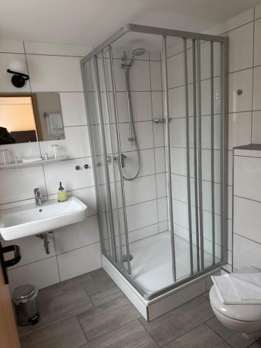 a bathroom with a shower and a sink at Deutsche Eiche Hotel & Restaurant in Grebenstein