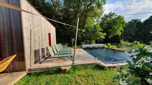 - une piscine avec une chaise longue verte à côté d'une maison dans l'établissement Le Clos d'Ô Maison de standing Le Milan avec sa piscine chauffée proche de Sarlat, à Prats-de-Carlux