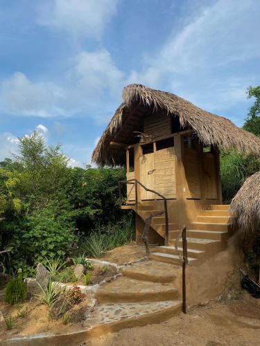 a small hut with a thatched roof and stairs at Habitación Privada Sol - Aldea Corazón - StarLink in Santa María Tonameca