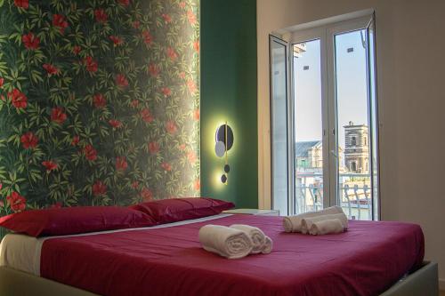 a bedroom with a red bed with towels on it at WANDERLUST SPACCANAPOLI Points Of View in Naples