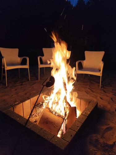 a fire pit with chairs and chairs around it at Chata Braci Warchały in Warchały