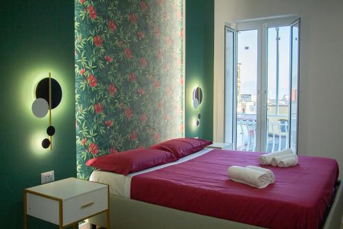 a bedroom with a bed with red sheets and a window at WANDERLUST SPACCANAPOLI Points Of View in Naples