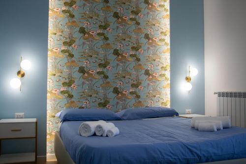 a bedroom with a blue bed with towels on it at WANDERLUST SPACCANAPOLI Points Of View in Naples