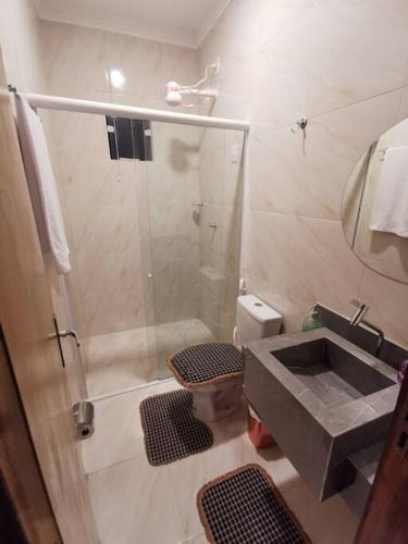 a bathroom with a shower and a sink at Rancho do Poeta - Chalé Umbucajá in Lagoa Nova