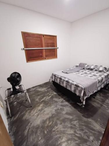 a white room with a bed and a window at Rancho do Poeta - Chalé Umbucajá in Lagoa Nova