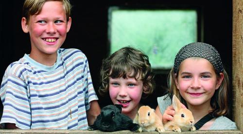 two boys and a girl with three small animals at Bio-Erlebnisbauernhof Doll in Nittenau
