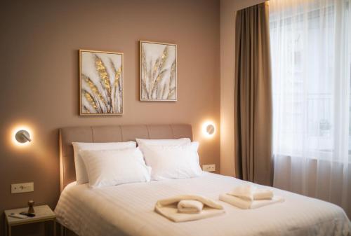 a bedroom with a bed with two towels on it at CityLuxe Center Ioannina in Ioannina