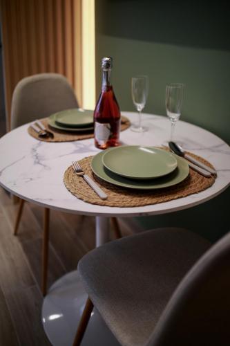 a table with two plates and a bottle of wine at CityLuxe Center Ioannina in Ioannina