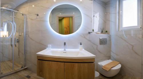 a bathroom with a sink and a shower and a toilet at CityLuxe Center Ioannina in Ioannina