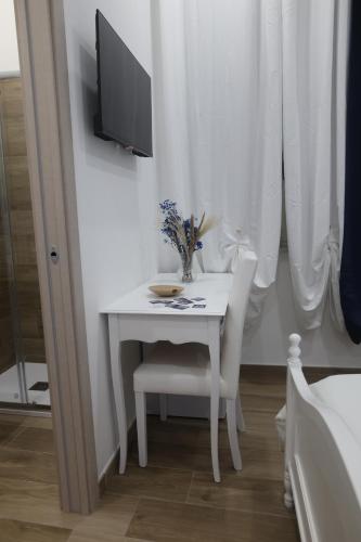 a white table with two chairs and a television on it at B&B AnMa in Ercolano